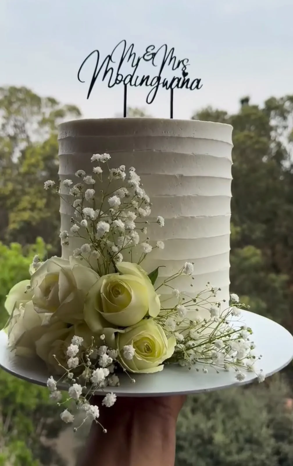 Baker decorating cakes in a bright professional kitchen